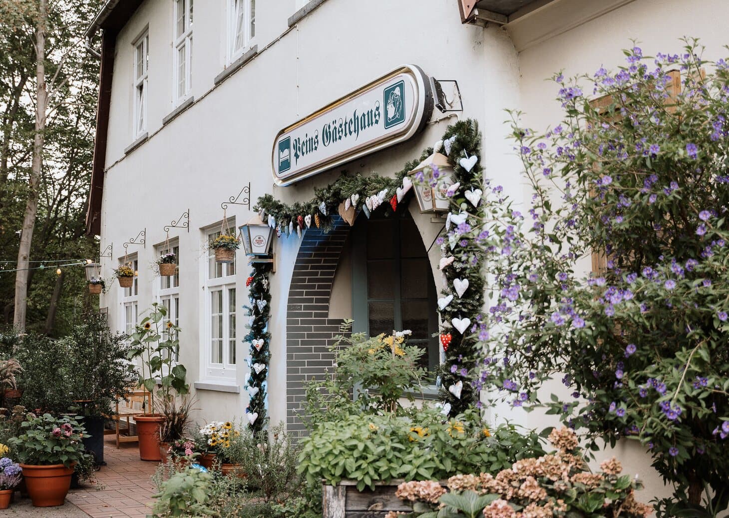 Eingang von Pein's Gästehaus mit bepflanztem Garten in Lilienthal bei Bremen